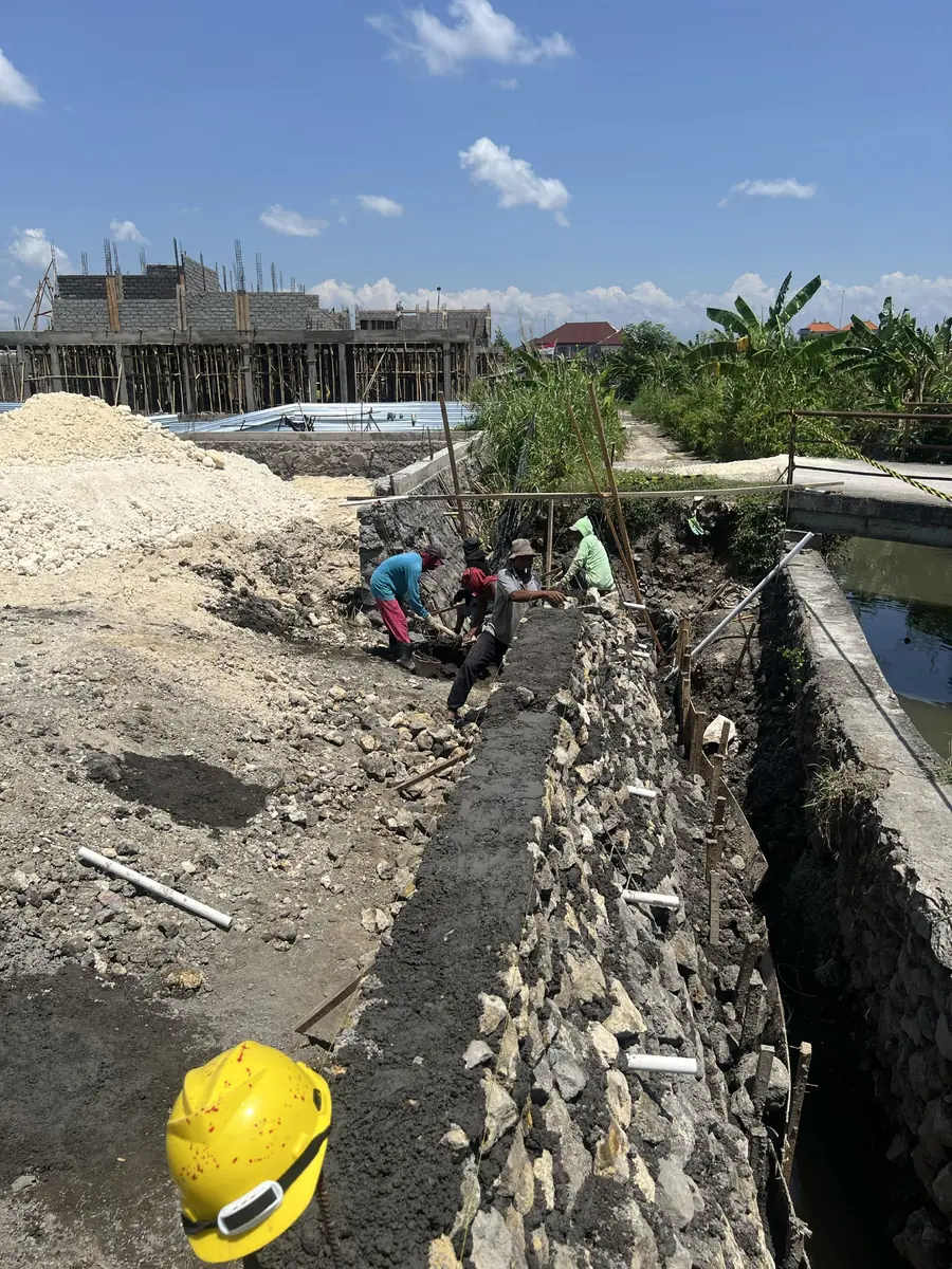 Workers finishing the boundary wall foundation